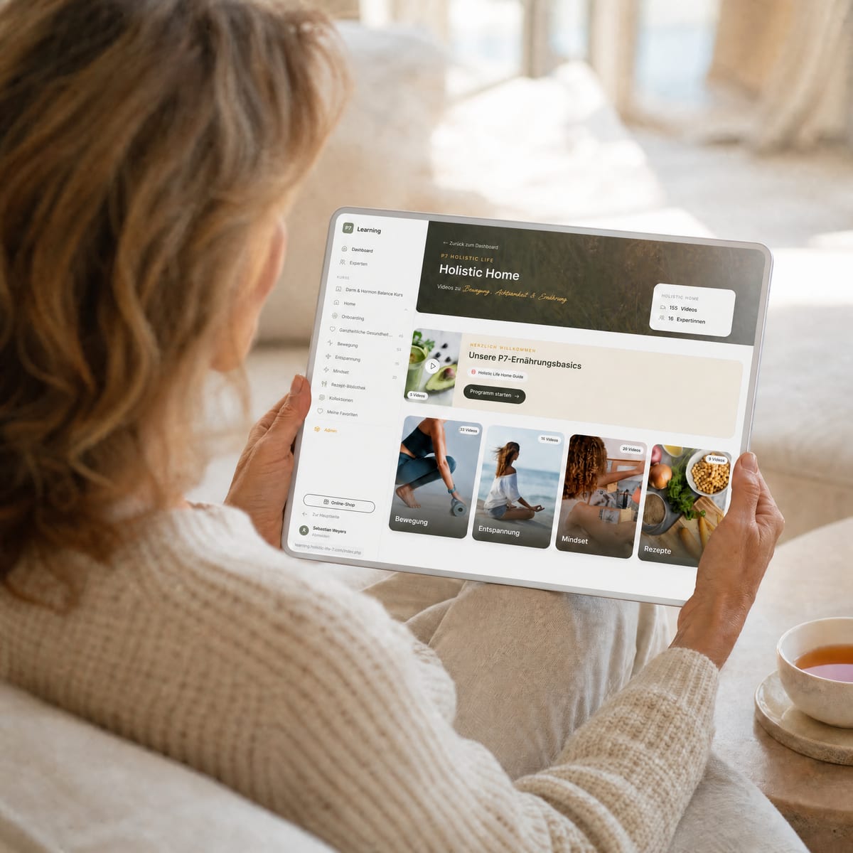 Frau nutzt die Holistic Life Home Membership entspannt auf dem Sofa