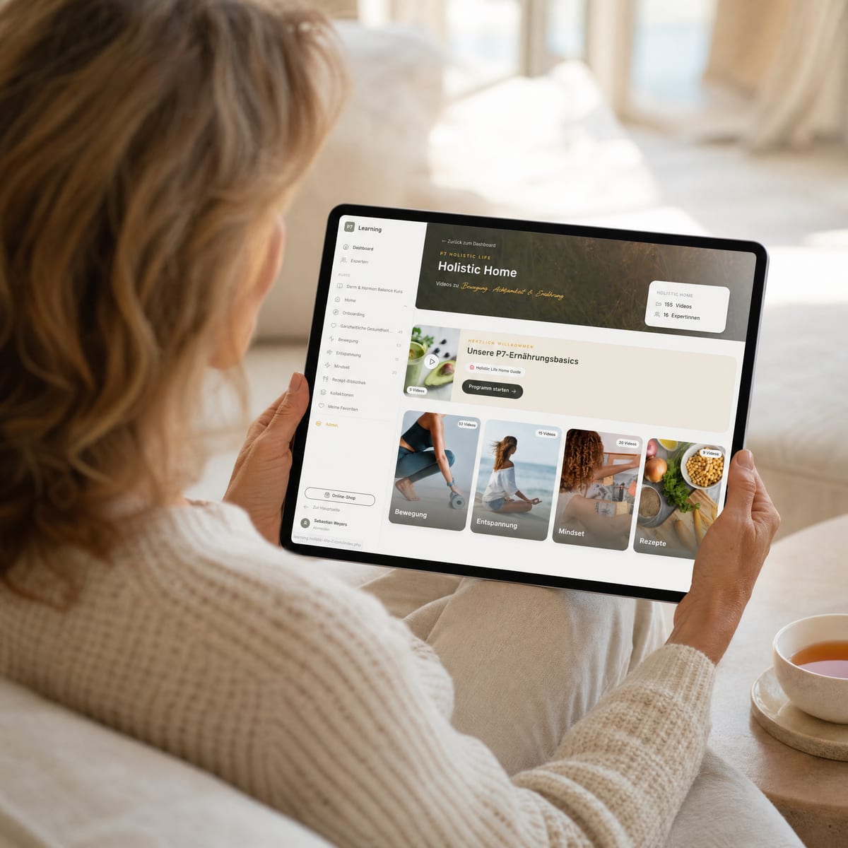 Frau nutzt die Holistic Life Home Membership entspannt auf dem Sofa